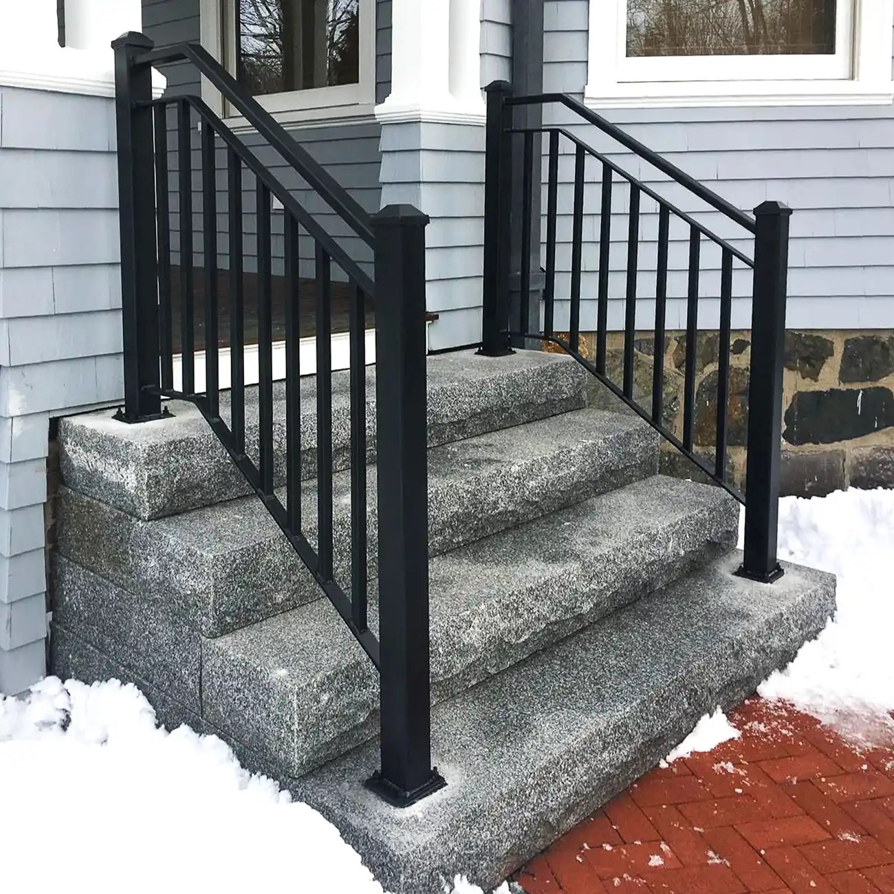 Black iron railing installed on granite front steps