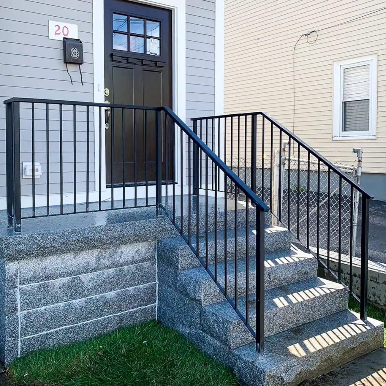 Black railing installed on front stairs and landing