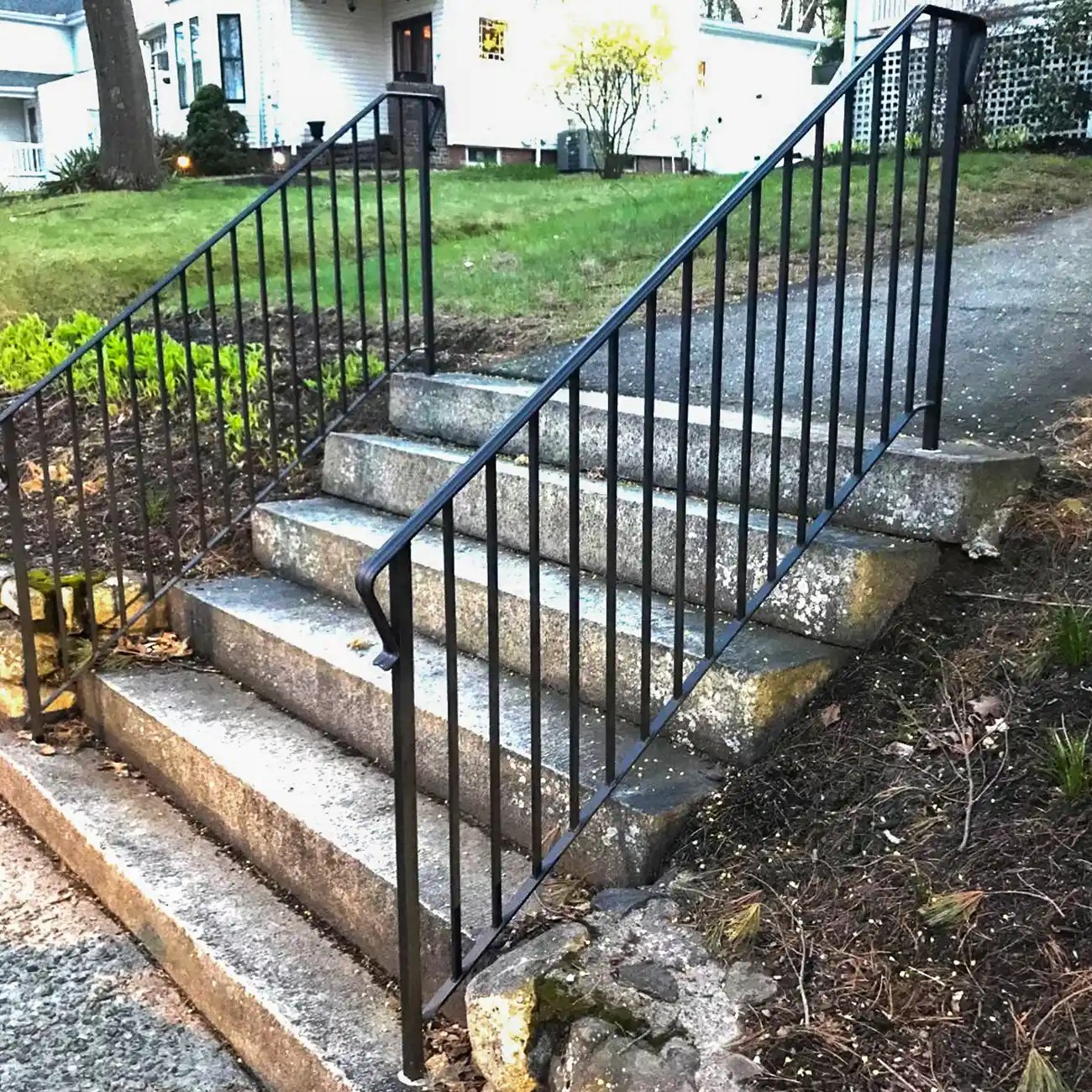 Black railing installed along exterior stone steps